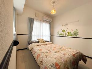 um pequeno quarto com uma cama e uma janela em EX Itoman Apartment 401 em Itoman