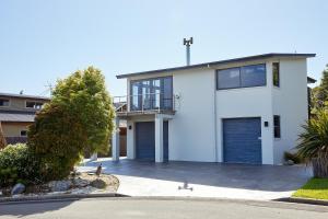 a white house with a garage at Bliss on the Bay in Kaikoura