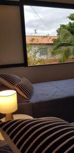 a bedroom with a bed and a large window at Casa Boutique Peró in Cabo Frio