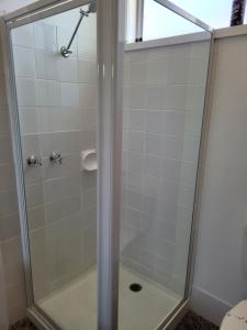 a shower with a glass door in a bathroom at Glynlea Motel in Horsham