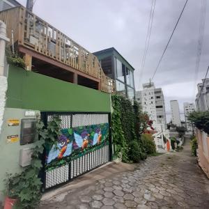 a green building with a balcony on the side of it at Suite confortável 5 in Florianópolis