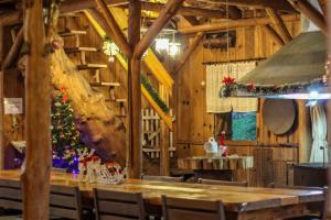 uma sala de jantar com uma árvore de Natal e uma mesa em Rancho do Lucas - Cabana e Chalé em São Bento do Sul