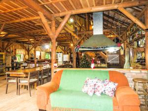 a green couch with pillows on it in a restaurant at Rancho do Lucas - Cabana e Chalé in São Bento do Sul