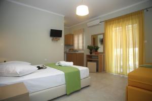 a hotel room with a bed and a kitchen at Pantazis Studios in Nikiana