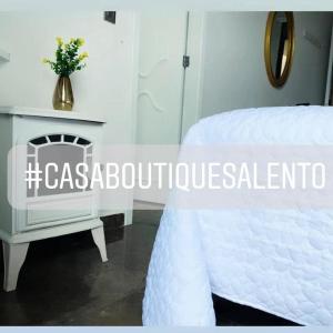 um quarto com uma cama branca e uma lareira em CASABOUTIQUE HOTEL em Salento