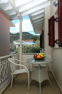 a table and chairs on a balcony with a bowl of fruit at Pantazis Studios in Nikiana