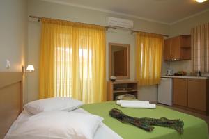 Habitación con 2 camas y cocina con cortinas amarillas. en Pantazis Studios, en Nikiana