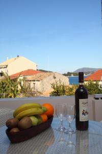 a table with a bowl of fruit and a bottle of wine at Pantazis Studios in Nikiana