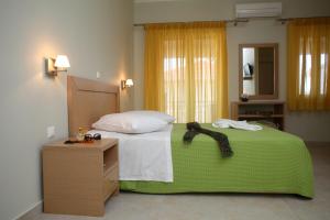 a bedroom with a bed with a green blanket and a dresser at Pantazis Studios in Nikiana +11 photos