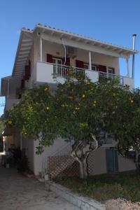 uma laranjeira em frente a um edifício em Pantazis Studios em Nikiana