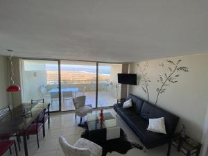 a living room with a couch and a table at Apartamento Puerto Velero Tongoy in Puerto Velero