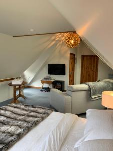 een slaapkamer met een bed, een bank en een tv bij Quail Farm, Colonial charm in Nelson