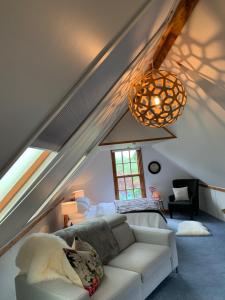 a living room with a white couch in a attic at Quail Farm, Colonial charm in Nelson