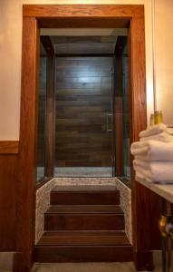a glass shower door with stairs in a bathroom at School 31 Lofts in Rochester