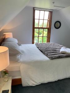 a white bed in a room with a window at Quail Farm, Colonial charm in Nelson