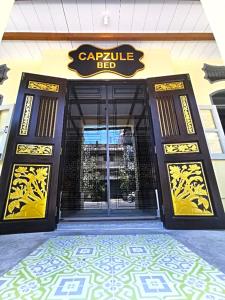 a building with a large door with a sign on it at Capzule Bed Phuket in Phuket