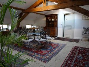 a dining room with a table and chairs on a rug at Gentilhommière de Collonges in Prissé