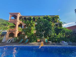 a woman in a yellow dress standing next to a swimming pool at Ninh Binh Greenland Homestay in Ninh Binh