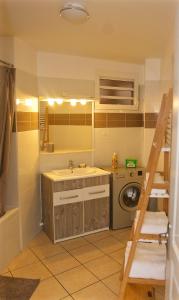 a bathroom with a sink and a washing machine at Le Nid Dor - Appartement de standing in Le Gosier