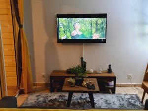 a living room with a flat screen tv on the wall at Le Nid Dor - Appartement de standing in Le Gosier