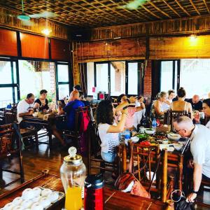 un groupe de personnes assises à table dans un restaurant dans l'établissement Ninh Binh Greenland Homestay, à Ninh Binh