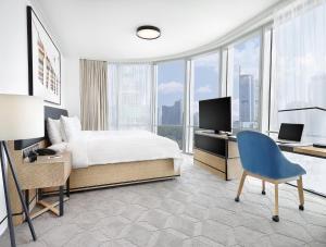a bedroom with a bed and a desk with a television at JEN Beijing by Shangri-La in Beijing