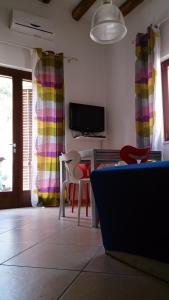 a living room with a table and chairs and a tv at Casa Vacanze Gorgonia in Castellammare del Golfo