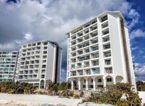 坎昆的住宿－Studio oceanfront prime location，海滩附近两栋大型白色建筑