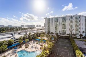 an aerial view of a resort with a pool and a tennis court at Luxury Miami Condos - 1BR-2BR & 3BR in Miami Beach