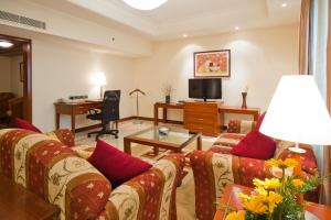 uma sala de estar com um sofá e uma mesa em The Accord Metropolitan em Chennai