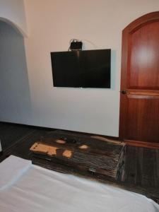 シルカシアにあるLos Tulios Alojamientoのベッドルーム1室(壁にテレビ付)、ベッド1台が備わります。