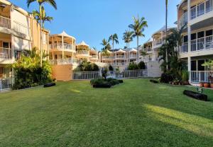 a large yard in front of some apartment buildings at Serenity Apartments Noosa in Noosa Heads