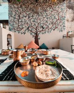 une table avec une plaque de nourriture sur une table dans l'établissement Vedaaranya Haveli, Ramgarh- AM Hotel Kollection, à Rāmgarh