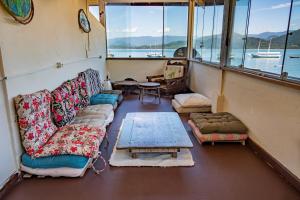 a room with couches and a table on a boat at Pousada Sobre As Ondas de Picinguaba in Picinguaba