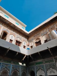 a building with a balcony and blue ceilings at Vedaaranya Haveli, Ramgarh- AM Hotel Kollection in Rāmgarh