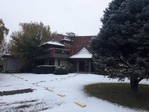 uma casa com neve no chão em frente dela em Hosteria Amparo em Neuquén