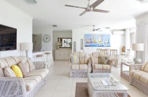a living room with couches and a table at Serenity Apartments Noosa in Noosa Heads