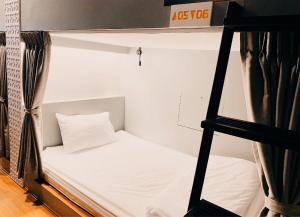 a room with a bunk bed and a ladder at Capzule Bed Phuket in Phuket
