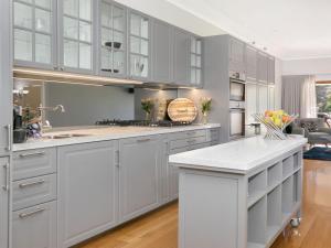 a kitchen with white cabinets and a white counter top at Advilla in Bowral