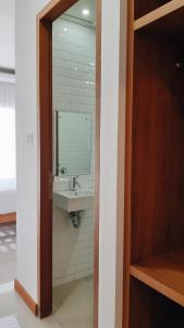 a bathroom with a sink and a mirror at RakaAyu Kuta in Kuta