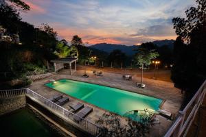 a swimming pool in a backyard at night at Southern Panorama Indriya Resorts & Spa in Munnar