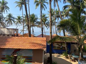 a beach with palm trees and palm trees at Art Resort Goa in Palolem