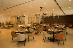 une salle à manger avec des tables et des chaises ainsi qu'un restaurant dans l'établissement Wynwood Hotel, à Manille