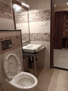 a bathroom with a toilet and a sink at GOLDEN AMULYA REST WINGS in Yelahanka
