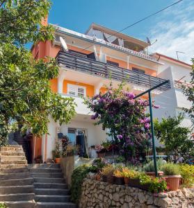 a house with stairs and flowers in front of it at Apartment Eneja in Rab