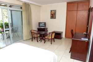 a living room with a table and a television at This Standard Suite offers a brilliant experience with the amenities offered in Kigali