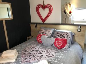 a bed with pillows with a heart on it at Escale Cocooning in Bruyères