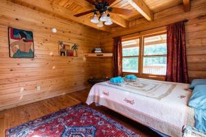 1 dormitorio con 1 cama en una cabaña de madera en PRIVATE Log Cabin with Indoor pool sauna and gym YOU RENT IT ALL NO ONE ELSE, en McAlpin