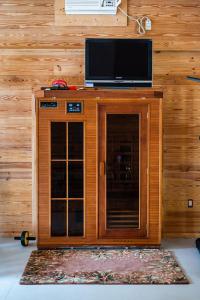 a wooden cabinet with a television on top of it at PRIVATE Log Cabin with Indoor pool sauna and gym YOU RENT IT ALL NO ONE ELSE in McAlpin