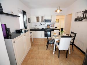 a kitchen with white cabinets and a table and chairs at Apartment Eneja in Rab